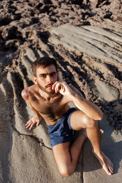 Full shot man with hairy chest at seaside