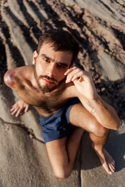 Full shot man with hairy chest at seaside