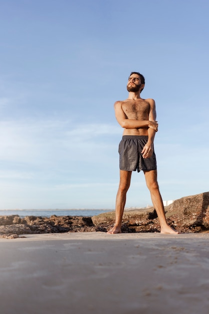 Full shot man with hairy chest at seaside