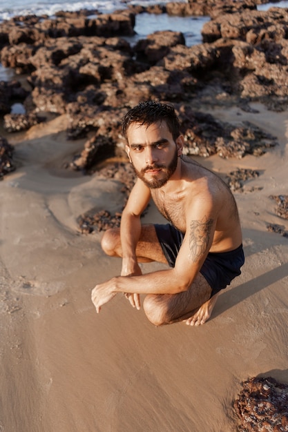 Full shot man with hairy chest at seaside