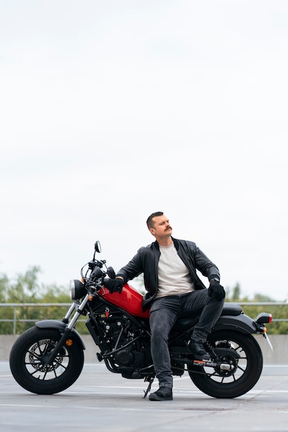 Full shot man with motorbike outdoors