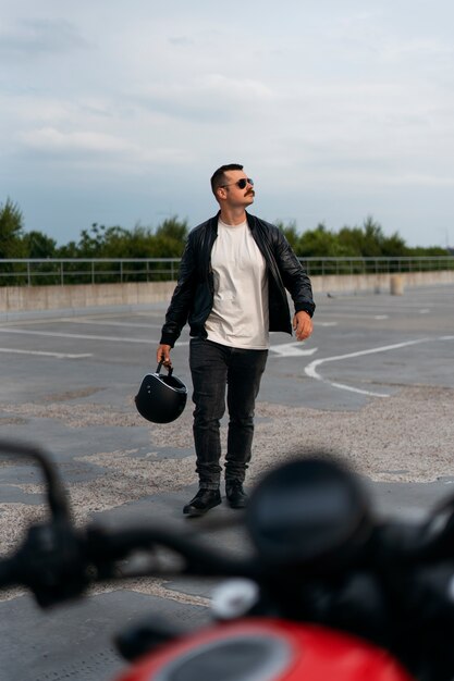 Full shot man with motorbike outdoors