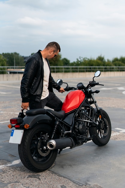 Full shot man with motorbike outdoors