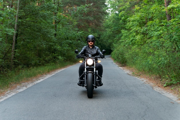 Full shot man with motorbike outdoors