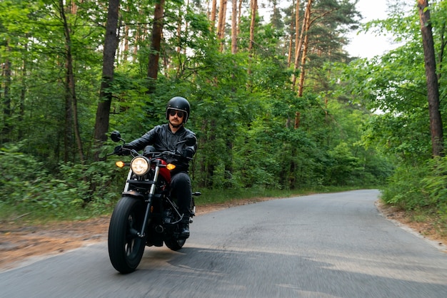 Full shot man with motorbike outdoors