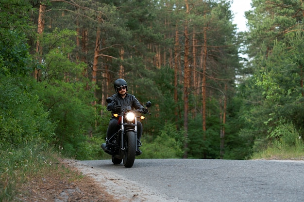 Full shot man with motorbike outdoors