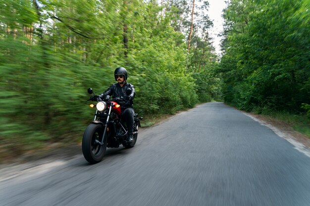 Full shot man with motorbike outdoors