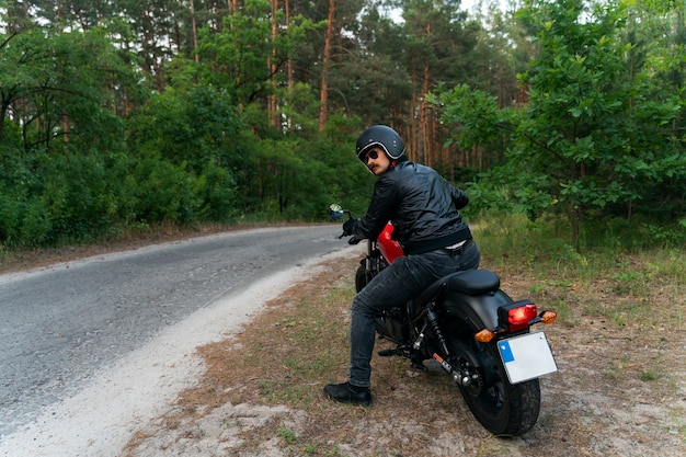 Full shot man with motorbike outdoors