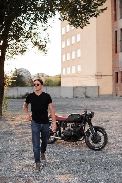 Free photo full shot man with motorcycle outdoors