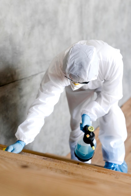 Free photo full shot man with suit disinfecting stairs