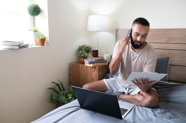 Full shot man working in bed