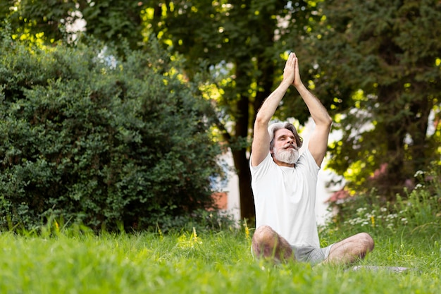 Free Photo full shot man on yoga mat outdoors