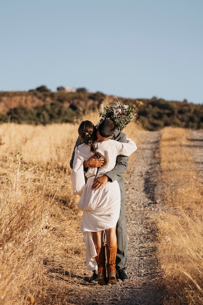 Free photo full shot married couple hugging outdoors