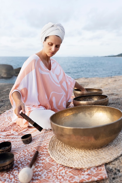 Free photo full shot meditation guide with singing bowls