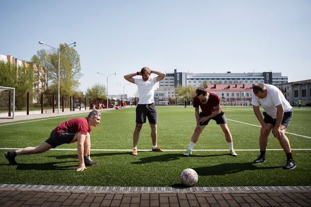 Free Photo full shot men stretching before game