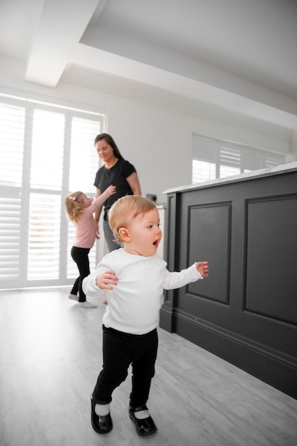 Free photo full shot mother and happy kids at home