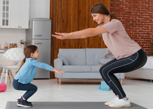 Full shot mother and kid exercising