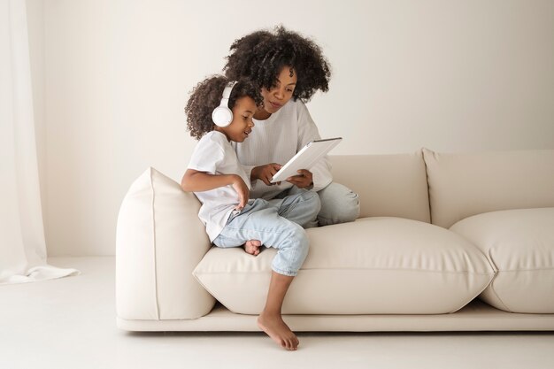 Full shot mother and kid with tablet