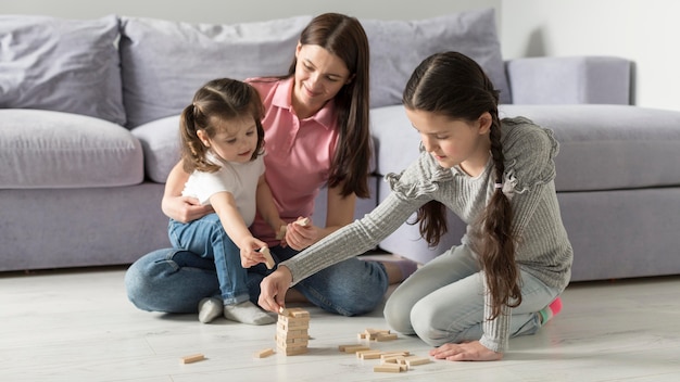 Full shot mother and kids on floor