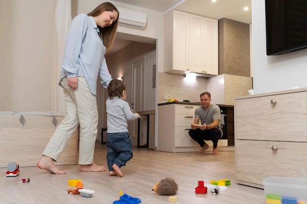 Full shot parents watching kid's first steps