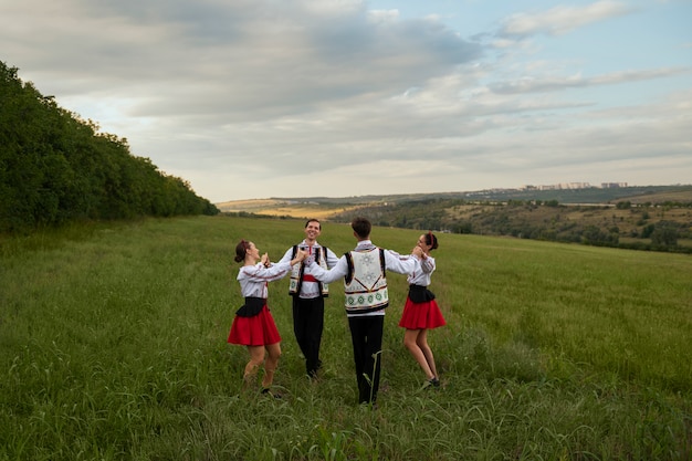 Full shot people dancing in nature