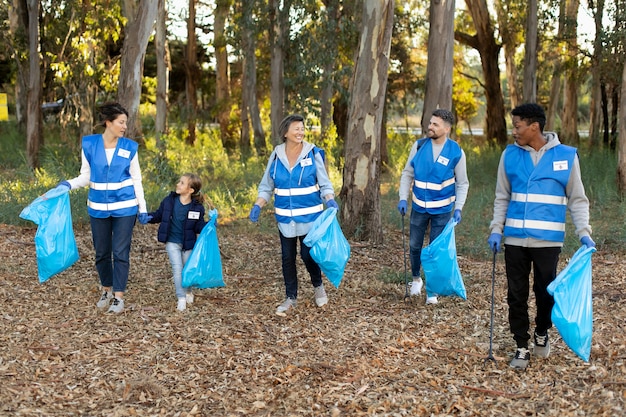 Full shot people holding garbage bags