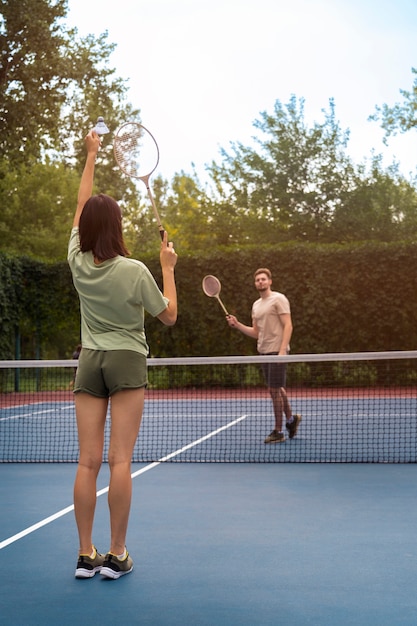 Free photo full shot people playing badminton