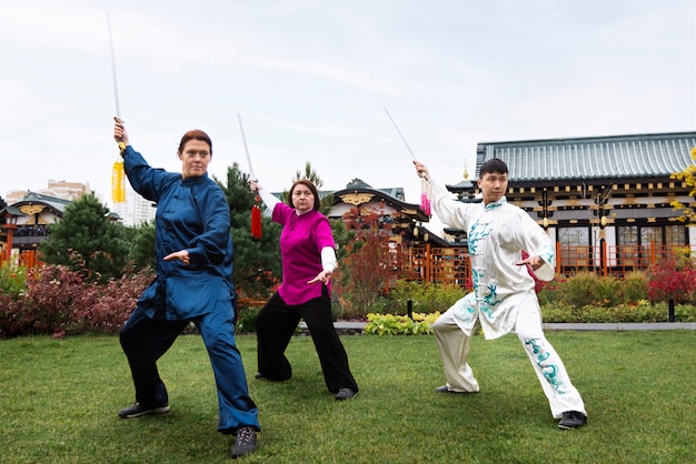 Full shot people practicing tai chi