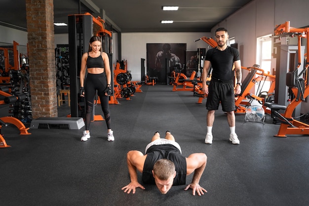 Full shot people watching man at gym