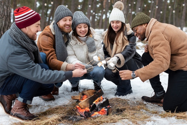 Free Photo full shot people with marshmallows by the fire