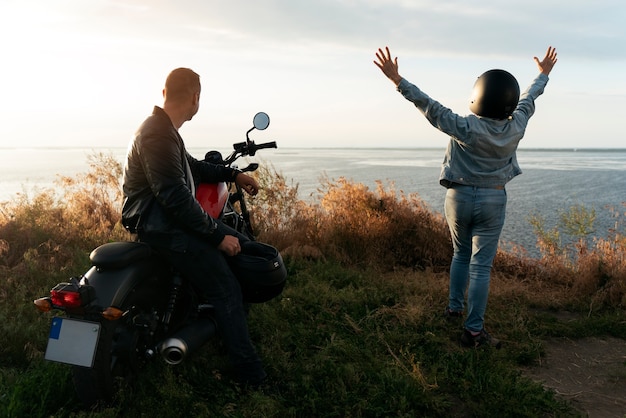 Free photo full shot people with motorbike outdoors