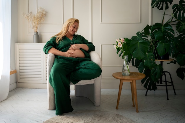 Full shot pregnant woman spending time indoors