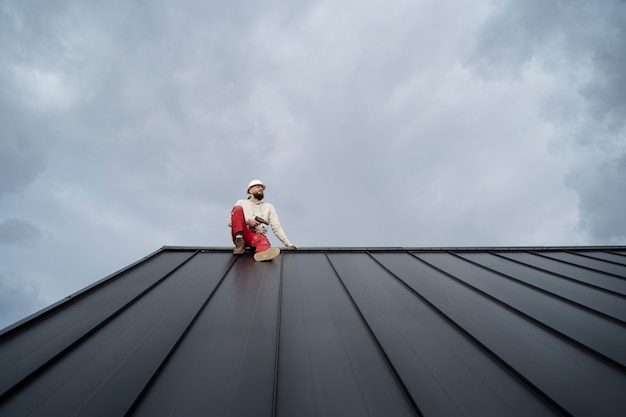 Free photo full shot roofer working with protection helmet