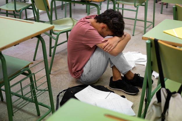 Full shot sad boy at school