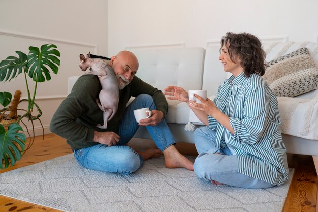 Full shot senior couple with cat at home