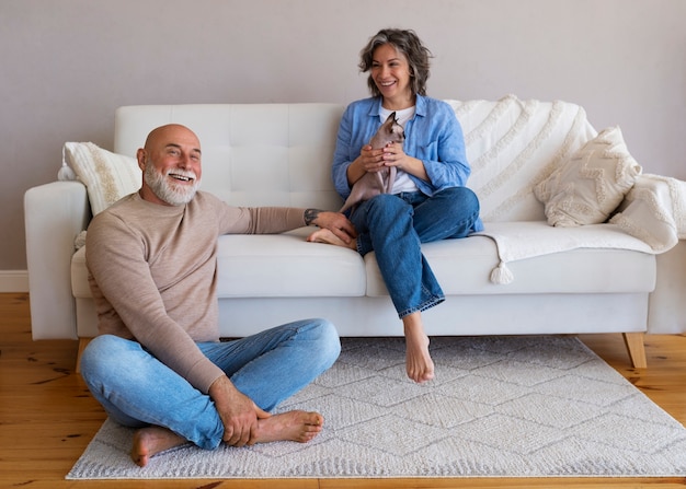 Full shot senior couple with cat at home