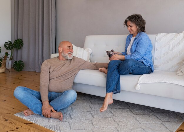 Full shot senior couple with cat at home