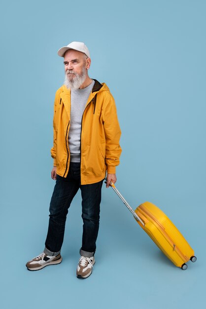 Full shot senior man portrait with baggage