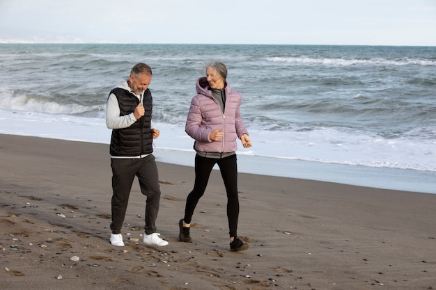 Full shot senior people running on beach