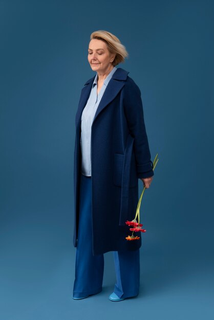 Full shot senior woman holding flowers