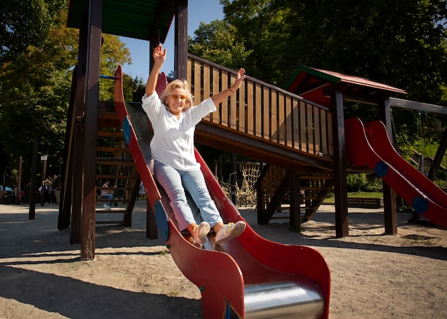 Free photo full shot senior woman on slide