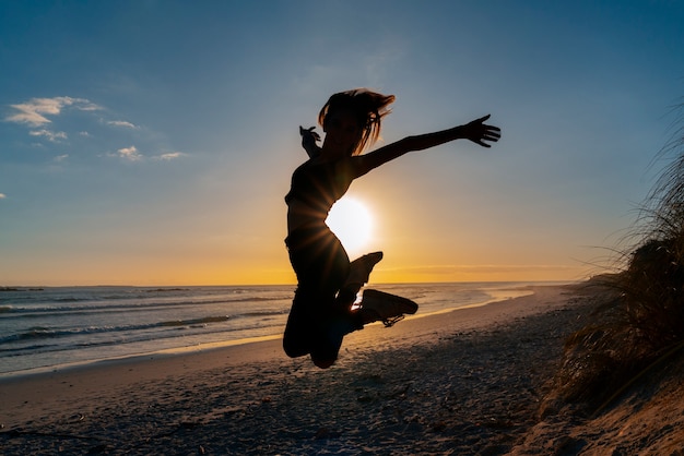 Free photo full shot  silhouette jumping at sunset