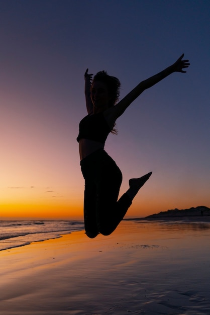 Free photo full shot  silhouette jumping at sunset