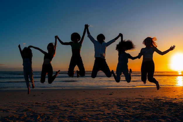 Free photo full shot  silhouettes of people jumping at sunset