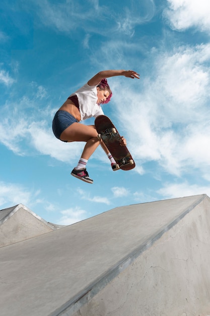 Full shot skater jumping  with board in park