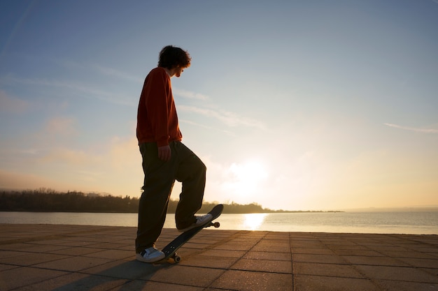 Free photo full shot skater posing at sunset