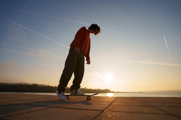 Free photo full shot skater posing at sunset