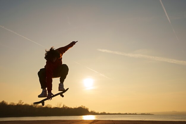 Full shot skater posing at sunset