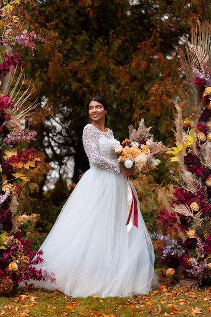 Full shot smiley bride posing with flowers