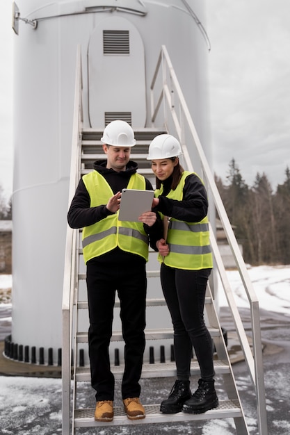 Full shot smiley engineers with tablet